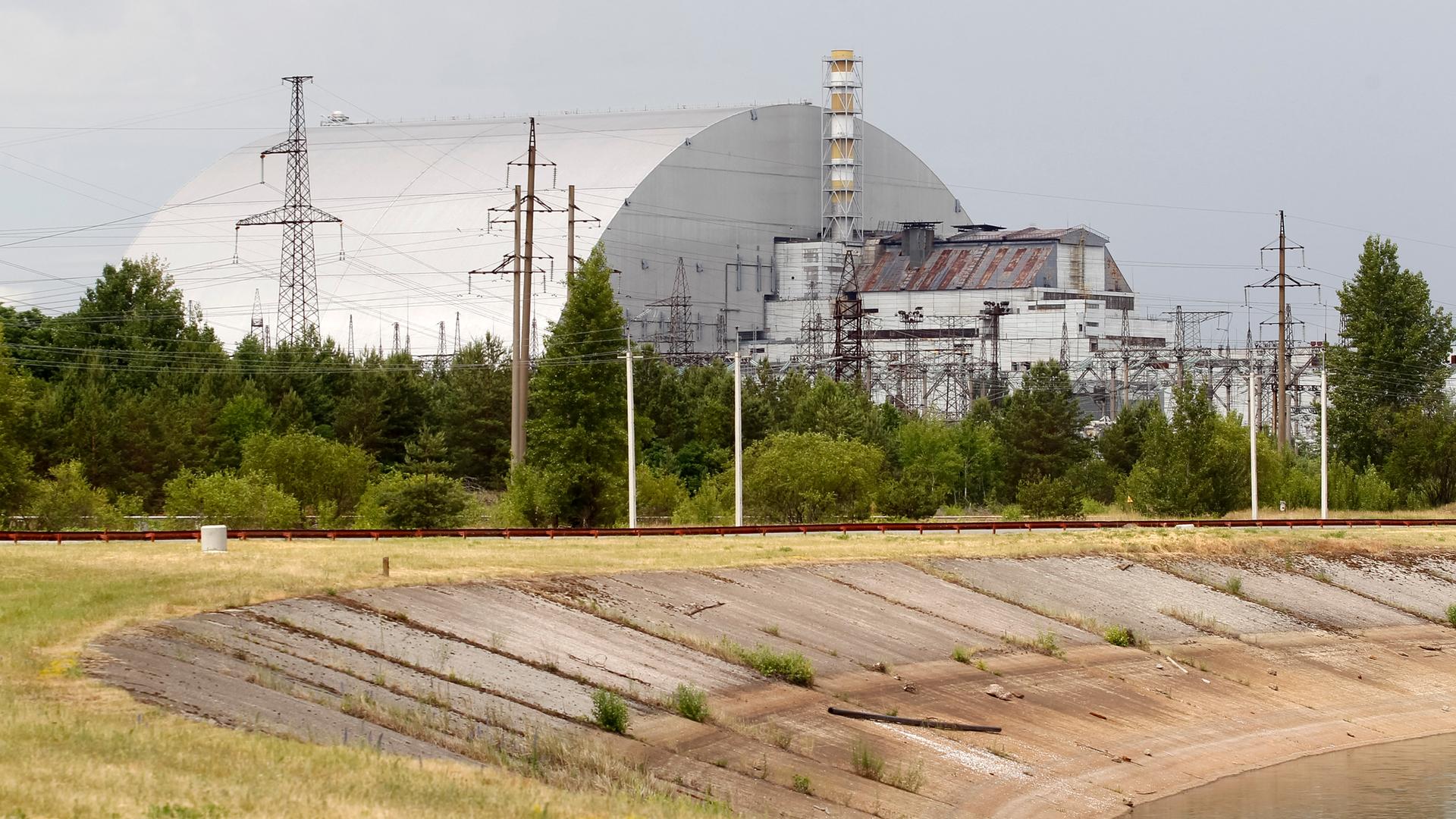 Blick auf die Schutzhülle über den Überresten des Reaktorblocks 4 im Kernkraftwerk Tschernobyl