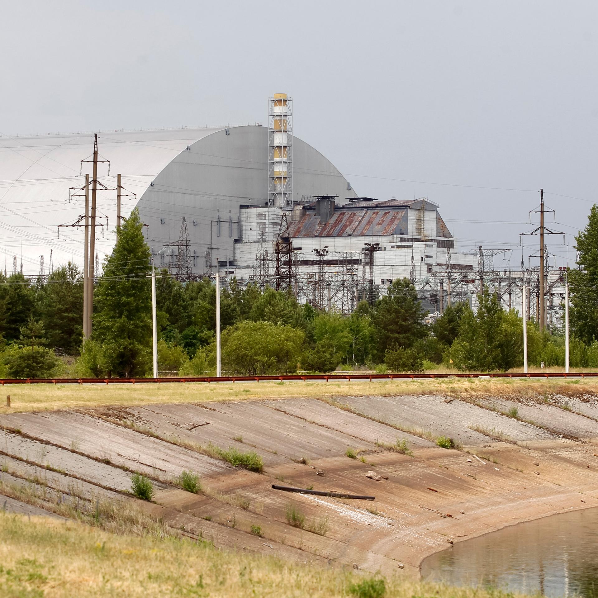 Blick auf die Schutzhülle über den Überresten des Reaktorblocks 4 im Kernkraftwerk Tschernobyl