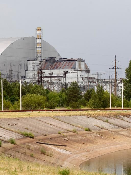 Blick auf die Schutzhülle über den Überresten des Reaktorblocks 4 im Kernkraftwerk Tschernobyl