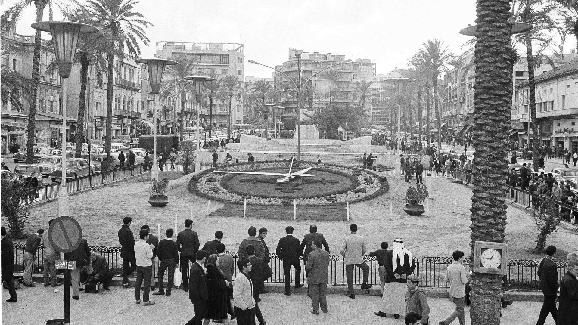Die Archivaufnahme zeigt einen runden Platz in Beirut mit Palmen, an Geländern stehen Menschen.