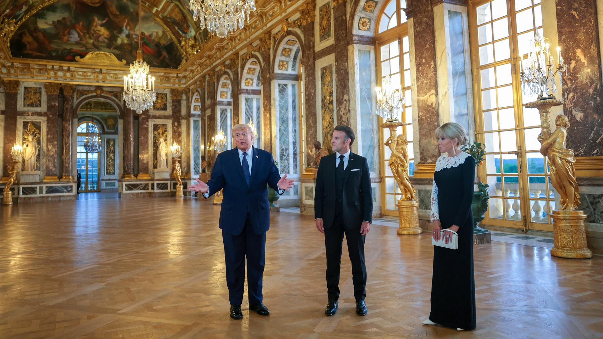 Das Foto zeigt US-Präsident Trump im Schloss von Versailles, daneben Frankreichs Präsident Macron und seine Frau Brigitté. Das Foto zeigt US-Präsident Trump im Schloss von Versailles, daneben Frankreichs Präsident Macron und seine Frau Brigitté.