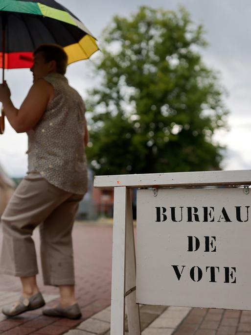 Eine Wählerin verlässt ein Wahllokal in Frankreich 