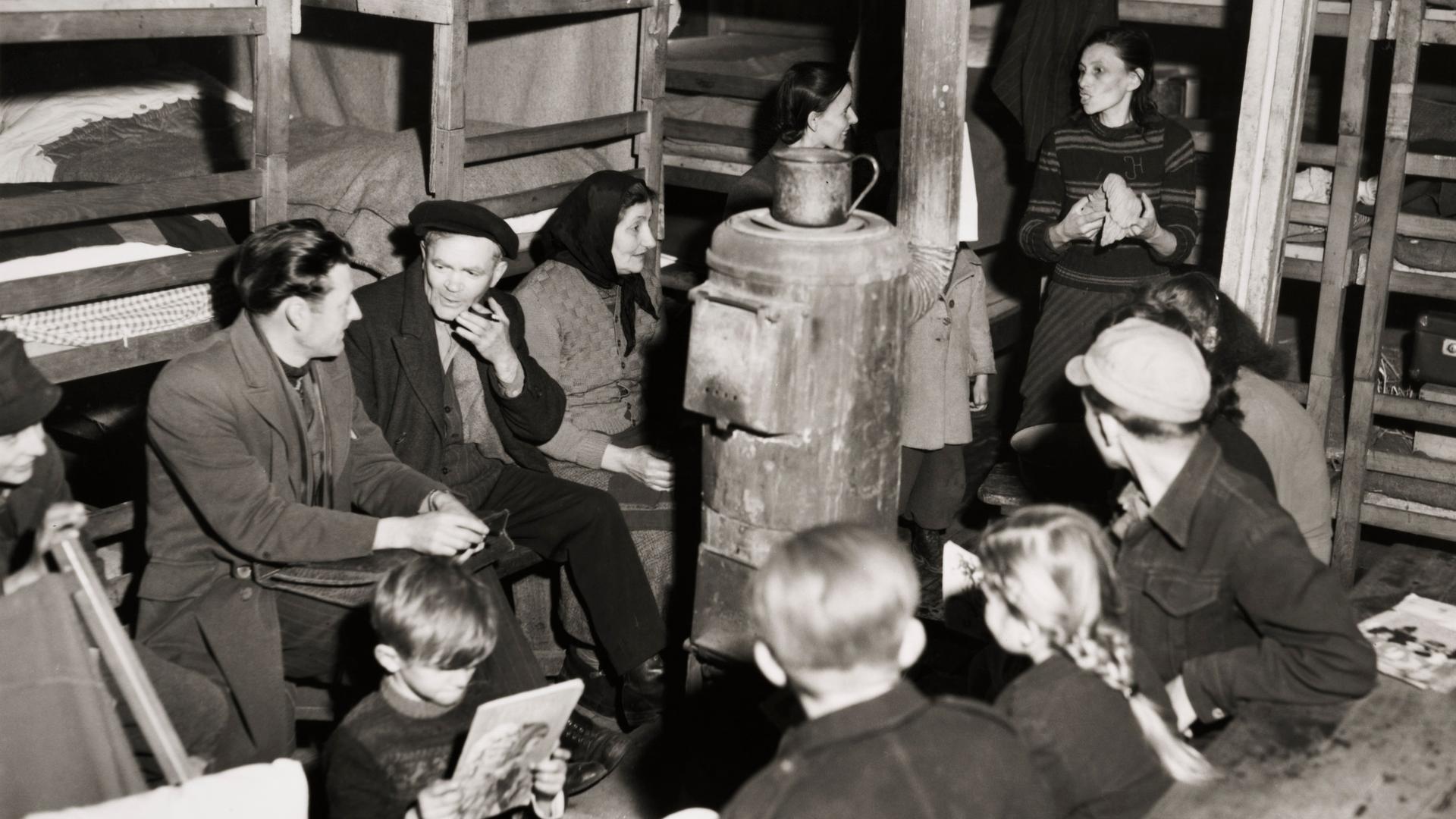 Eine Gruppe Menschen sitzt in einer Barracke in Uelzen.