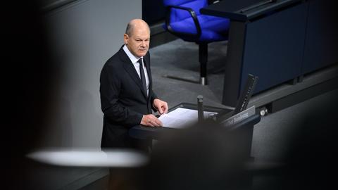 Scholz steht im schwarzen Jackett am Rednerpult und spricht.