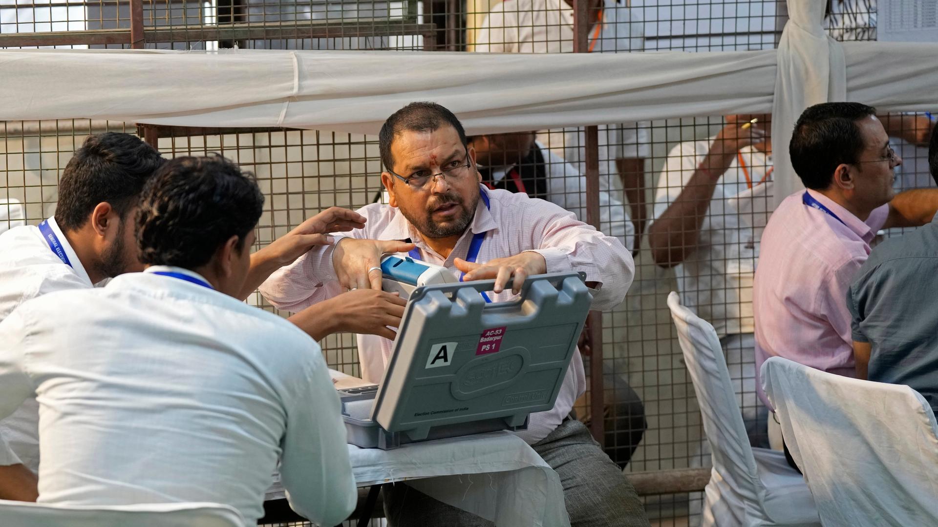 Indien, Neu Delhi: Wahlhelfer öffnen eine elektronische Wahlmaschine zur Auszählung der Stimmen in einem Auszählungszentrum in Neu-Delhi, Indien. Indien, Neu Delhi: Wahlhelfer öffnen eine elektronische Wahlmaschine zur Auszählung der Stimmen in einem Auszählungszentrum in Neu-Delhi, Indien.