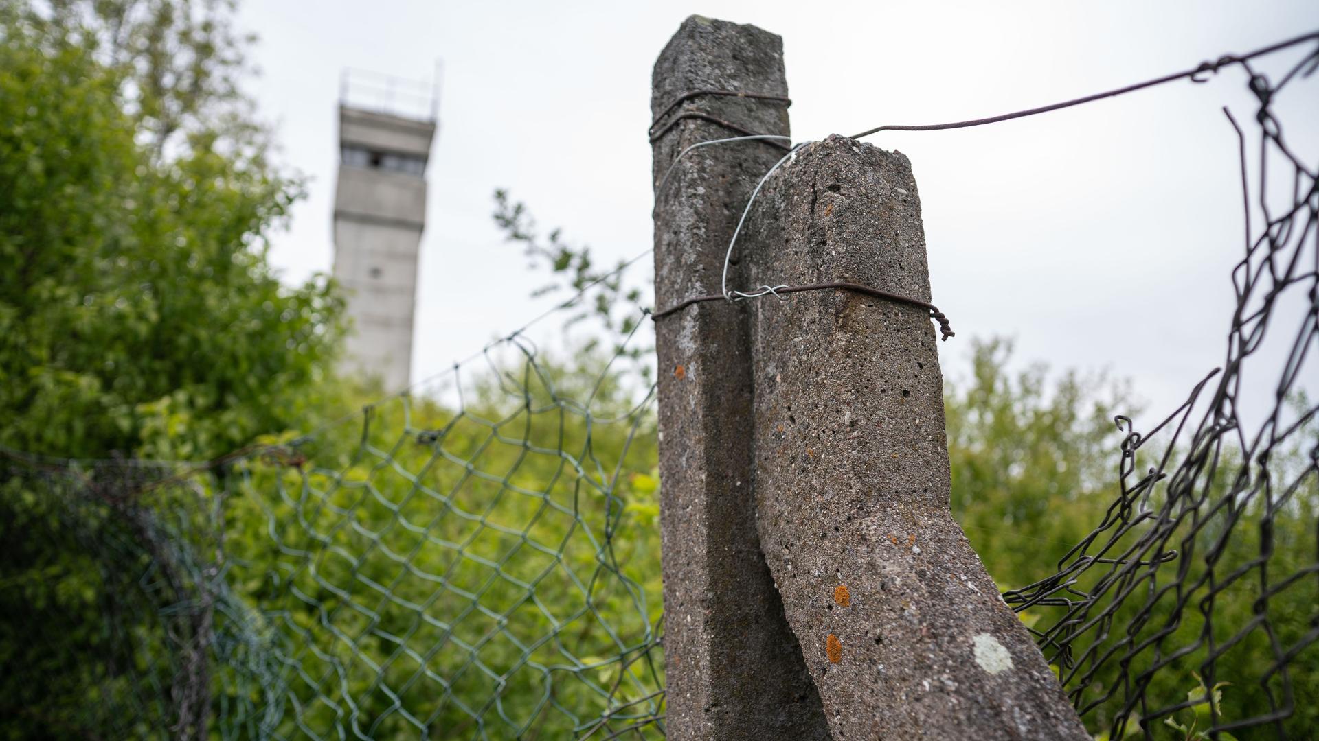 Ein alter Betonpfosten und ein Grenzturm sind noch am Rande des ehemaligen Grenzübergang Herleshausen auf dem Gebiet der ehemaligen DDR-Grenzanlagen bei Eisenach zu sehen.