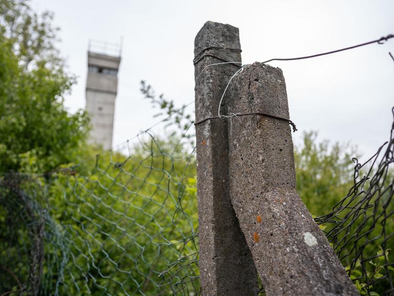 Ein alter Betonpfosten und ein Grenzturm sind noch am Rande des ehemaligen Grenzübergang Herleshausen auf dem Gebiet der ehemaligen DDR-Grenzanlagen bei Eisenach zu sehen.