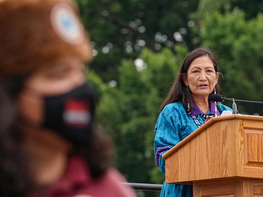 Innenministerin Deb Haaland steht an einem Rednerpult und spricht ins Mikrofon.
