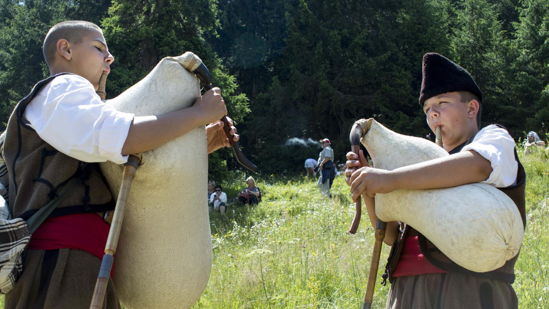 Zwei Dudelsackspieler stehen auf einer Wiese Zwei Dudelsackspieler stehen auf einer Wiese