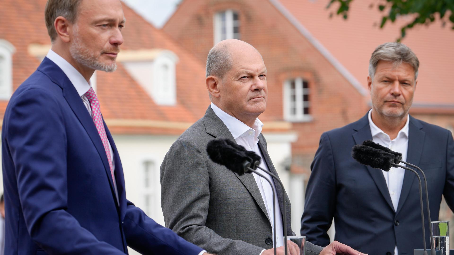 Finanzminister Christian Lindner (FDP) gemeinsam mit Bundeskanzler Olaf Scholz (SPD) und Wirtschaftsminister Robert Habeck (Die Grünen) bei der Pressekonferenz zum Abschluss der Kabinettsklausur auf Schloss Meseberg, Gransee, am 30.08.2023.