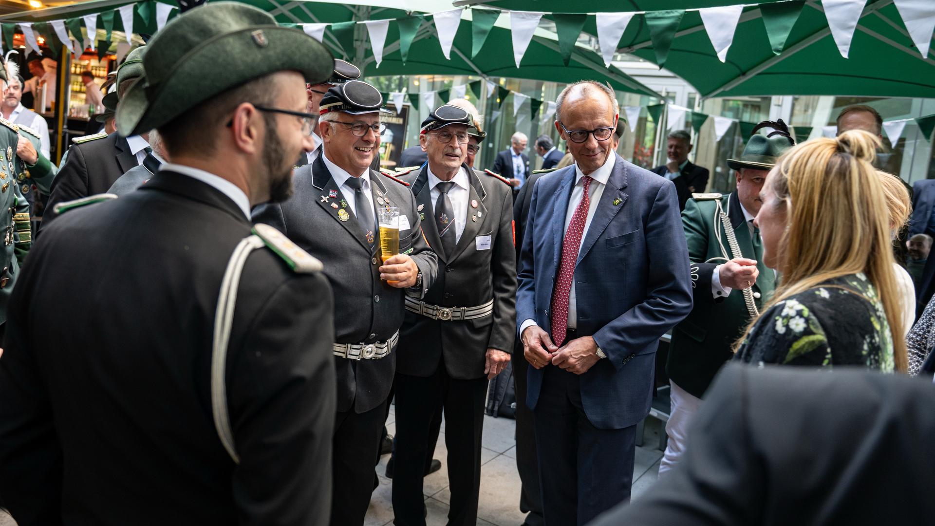 Berlin: Bundeskanzler Friedrich Merz (CDU) steht beim traditionellem Schützenfest der Sauerländer Botschaft in der Landesvertretung Nordrhein-Westfalen neben Mitgliedern eine Schützenvereins.