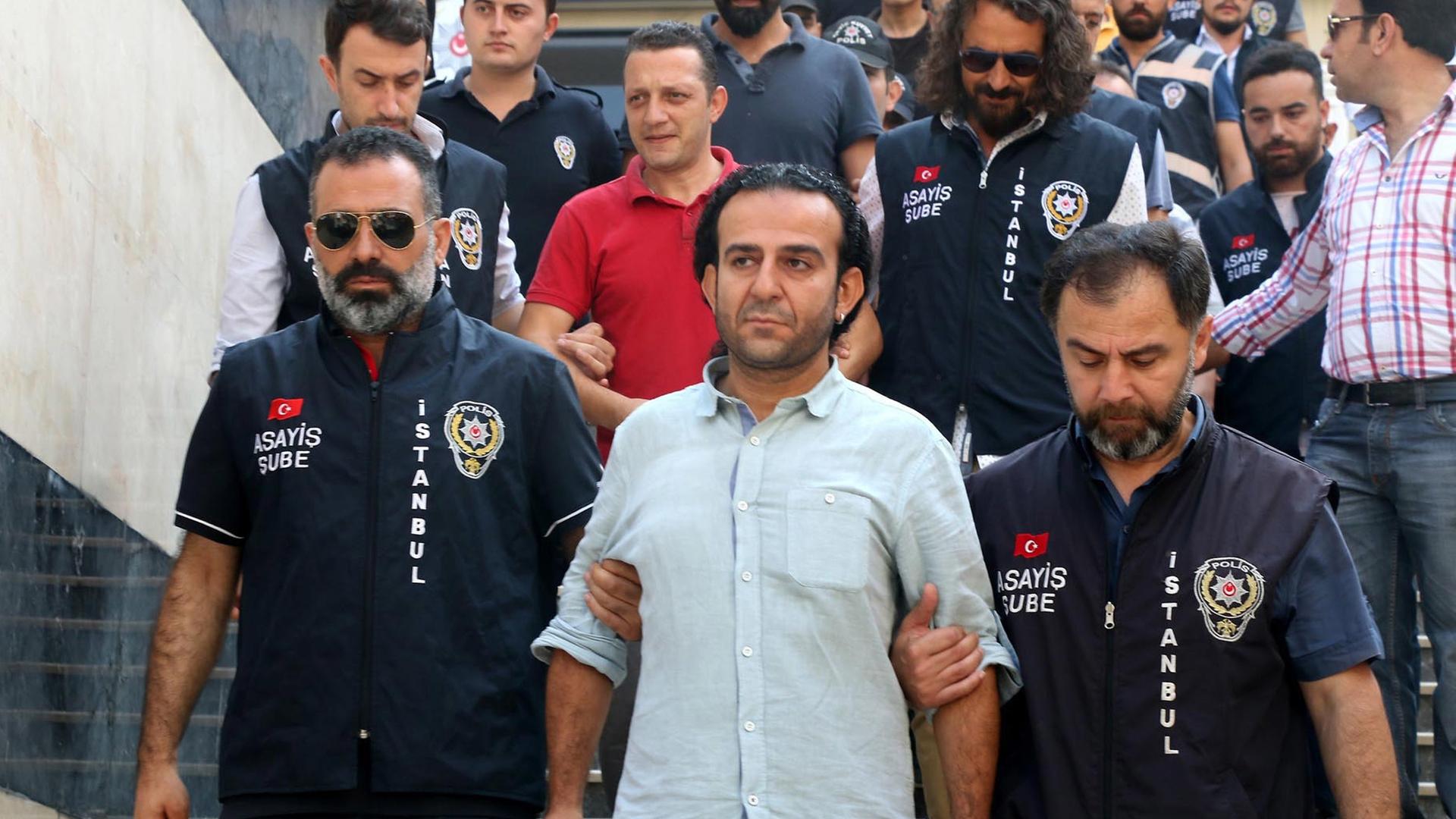 Polizisten geleiten den Journalisten Bülent Mumay zu einem Gericht in Istanbul.