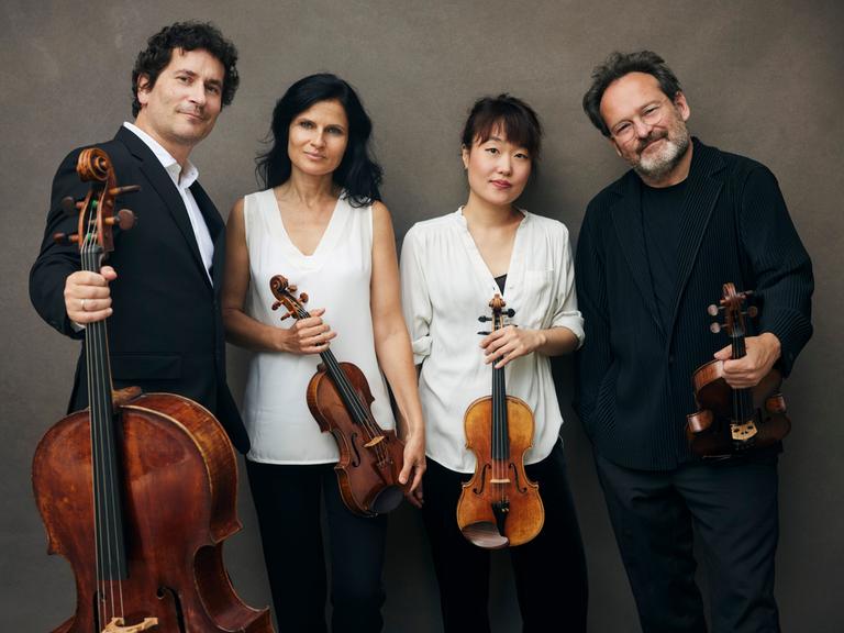 Zwei Musiker rahmen zwei Musikerinnen auf dem Gruppenfoto mit Instrumenten: das Belcea Quartett.