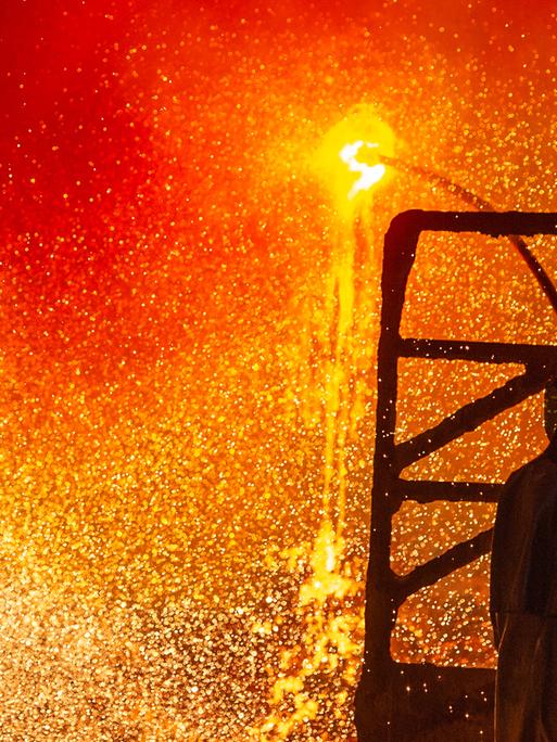 Ein Mitarbeiter reinigt im Stahlwerk der Salzgitter AG eine Roheisenpfanne. Funken sprühen. Ein Mitarbeiter reinigt im Stahlwerk der Salzgitter AG eine Roheisenpfanne. Funken sprühen.