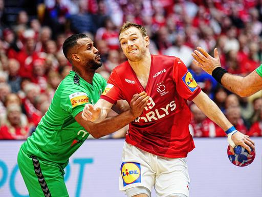 Mathias Gidsel von der dänischen Handball-Nationalmannschaft im Duell mit Algeriens Messaoud Berkous.