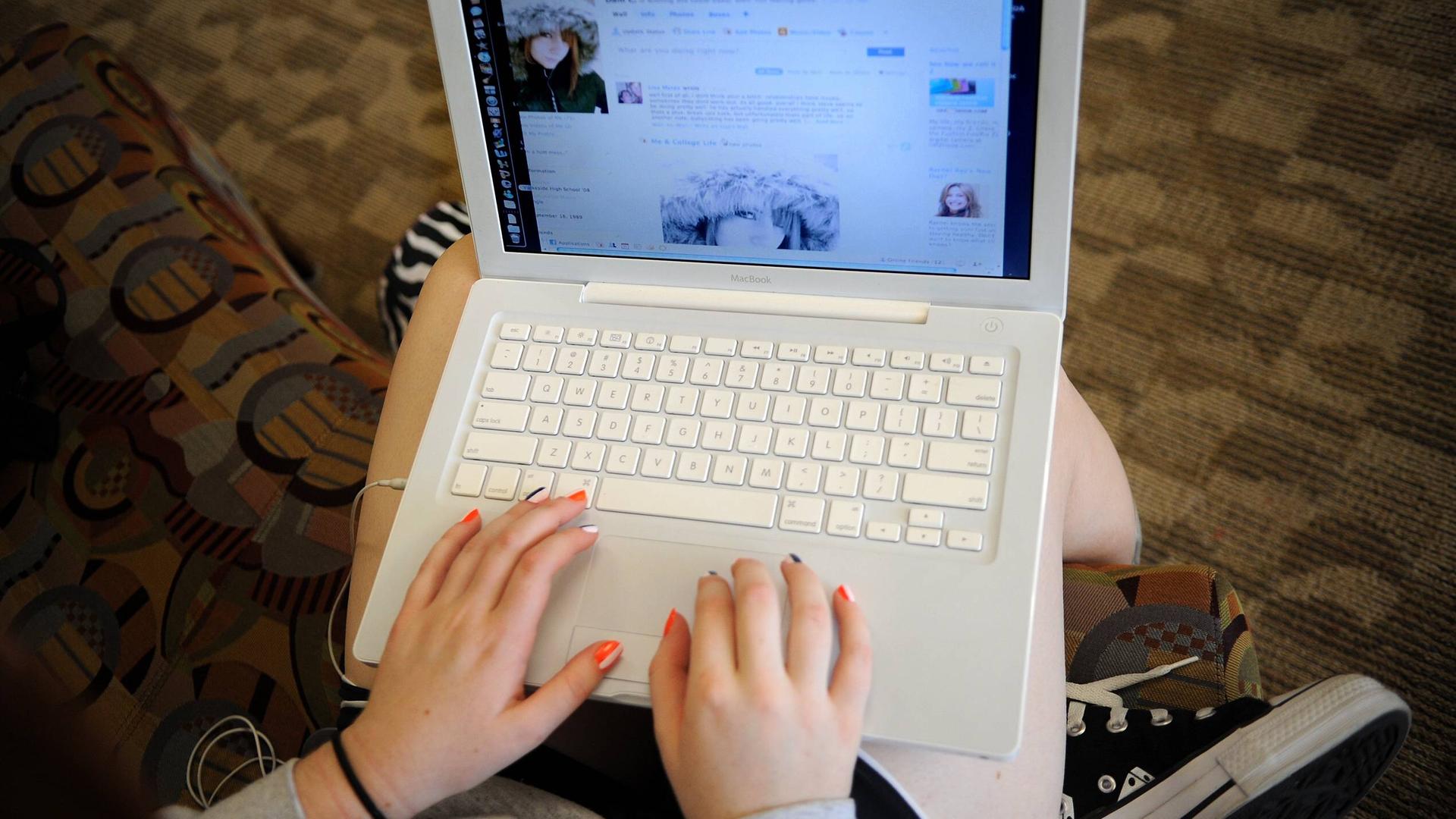 Foto aus dem Jahr 2008: Blick über die Schulter eines Mädchens, das an einem Laptop Facebook nutzt.