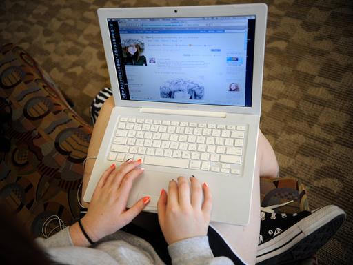 Foto aus dem Jahr 2008: Blick über die Schulter eines Mädchens, das an einem Laptop Facebook nutzt.