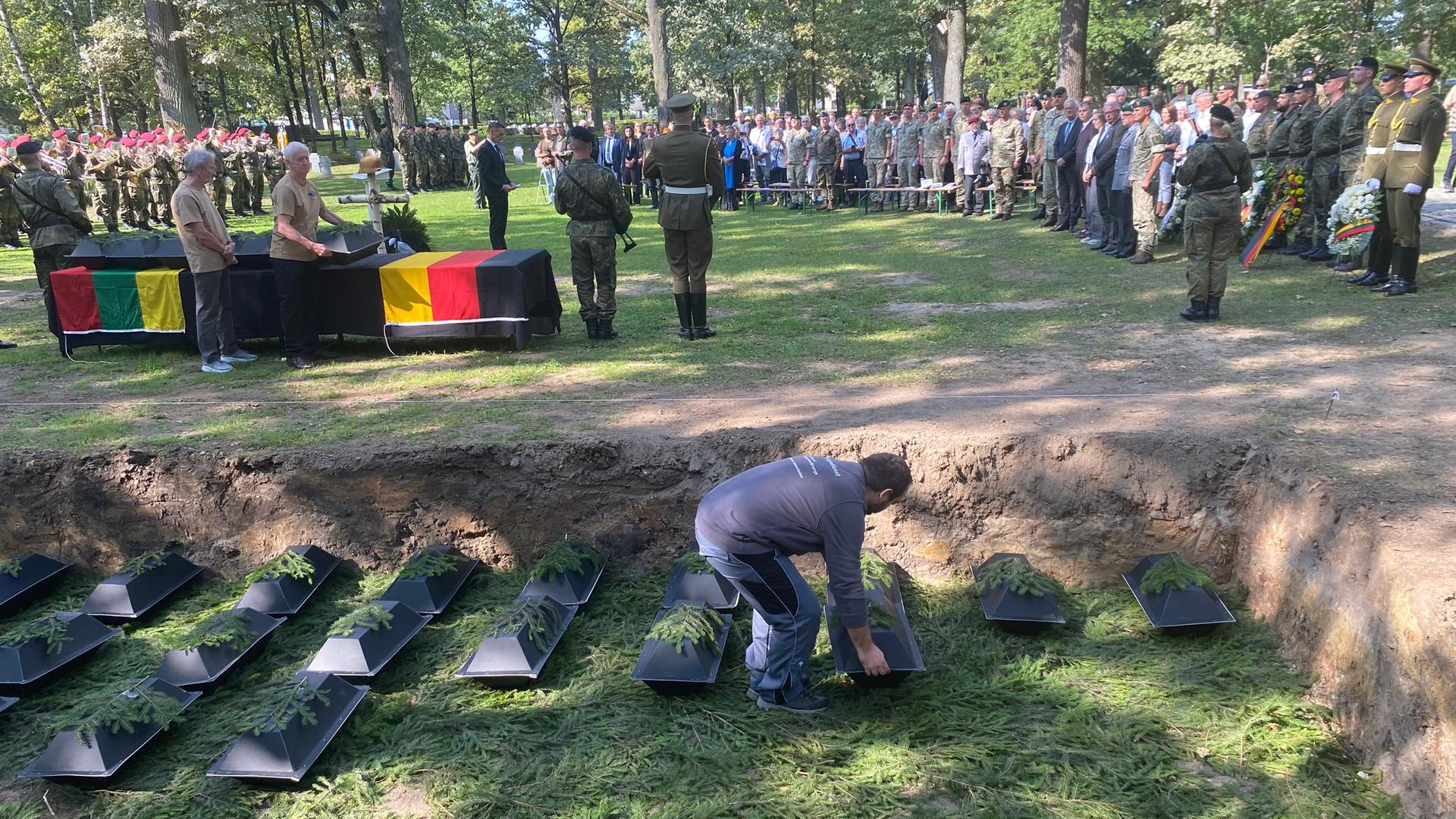 Ein Umbetter des Volksbunds stellt einen Sarg mit den sterblichen Überresten eines deutschen Kriegtoten in die Grabstätte. Ein Umbetter des Volksbunds stellt einen Sarg mit den sterblichen Überresten eines deutschen Kriegtoten in die Grabstätte.
