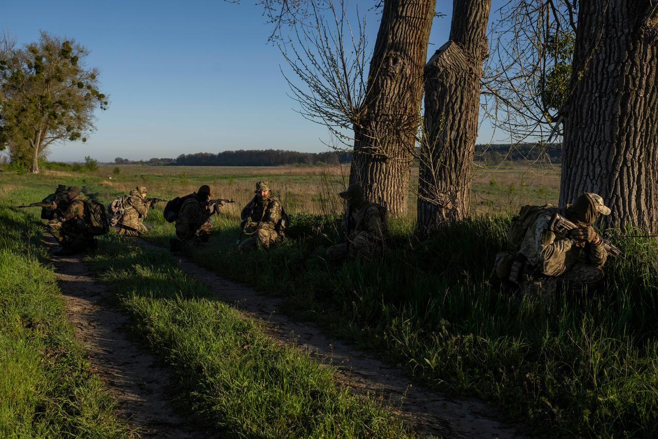 Ukrainische Soldaten auf einem Feldweg mit Gewehren.