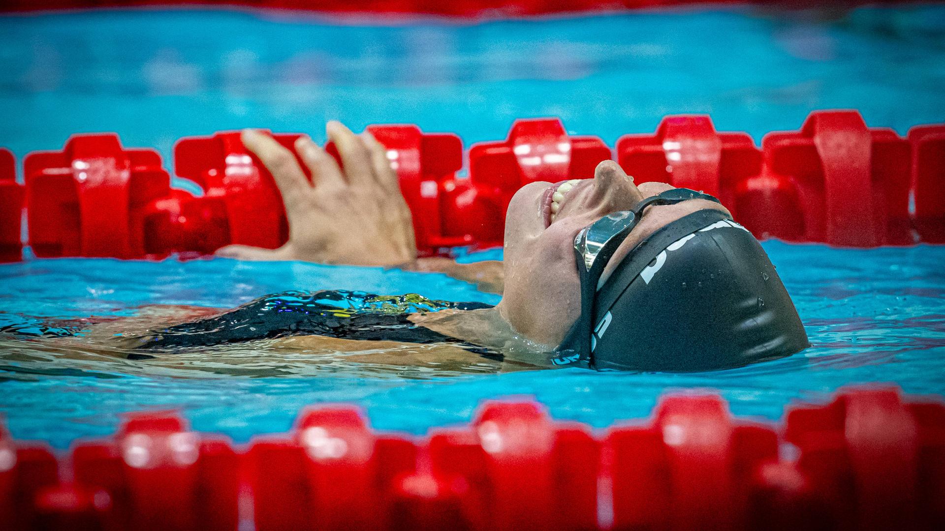 Tanja Scholz liegt auf dem Rücken im Wasser und lächelt.