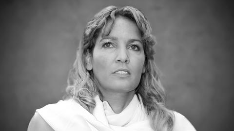 Zu sehen ist Nadja Abd el Farrag auf einem Schwarz-Weiß-Foto. Sie trägt ein weißes, ärmelloses Oberteil. 