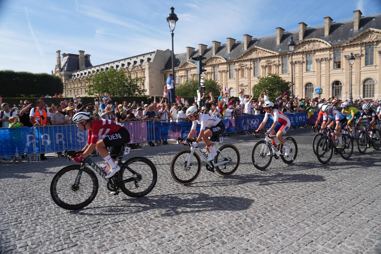 Die deutsche Straßenrad-Spezialistin Franziska Koch (Nr. 36, 2.v.l.) fährt bei den Olympischen Spielen in Paris über das Kopfsteinpflaster am Louvre.