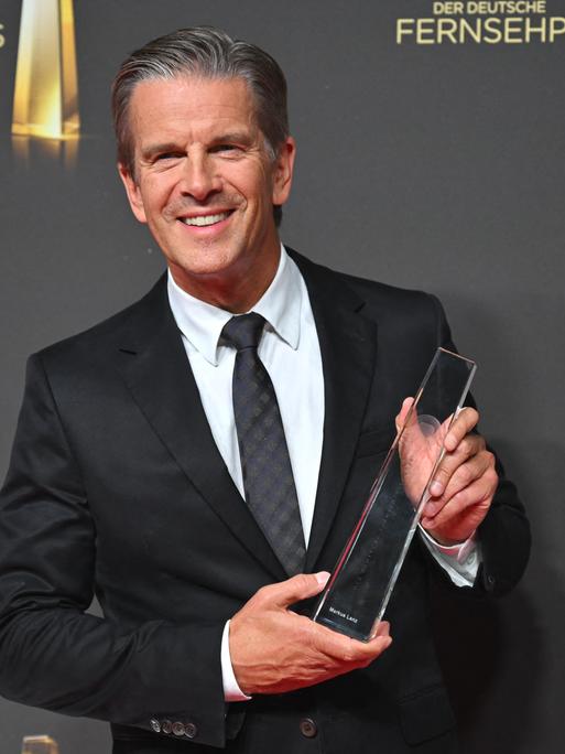 Moderator Markus Lanz hält den Deutschen Fernsehpreis in der Kategorie "Beste Information" in seinen Händen.