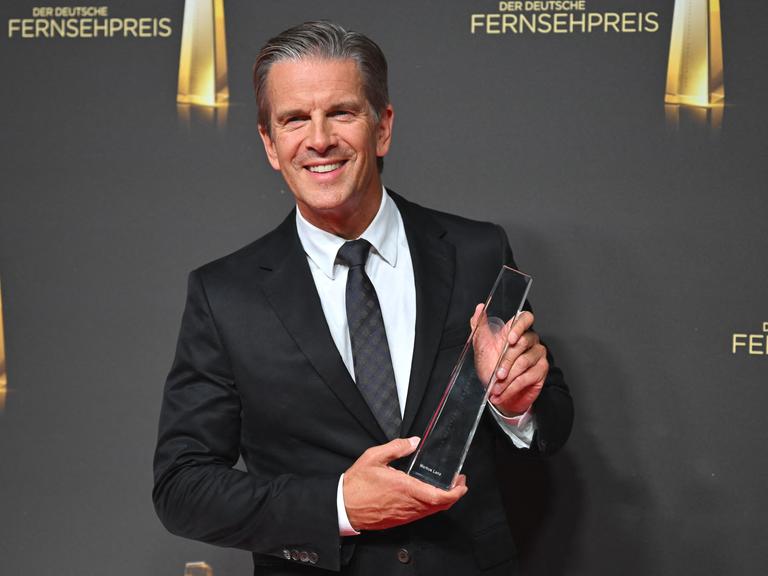 Moderator Markus Lanz hält den Deutschen Fernsehpreis in der Kategorie "Beste Information" in seinen Händen.