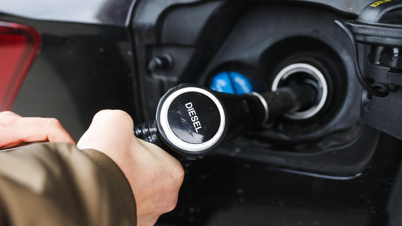 Frauenhände halten eine Diesel-Zapfpistole beim Betanken eines Fahrzeugs Frauenhände halten eine Diesel-Zapfpistole beim Betanken eines Fahrzeugs