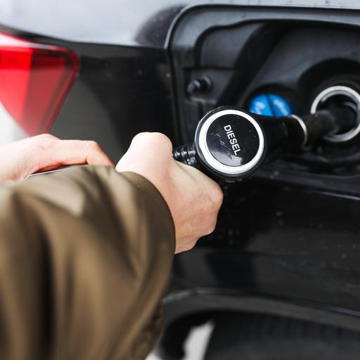 Frauenhände halten eine Diesel-Zapfpistole beim Betanken eines Fahrzeugs