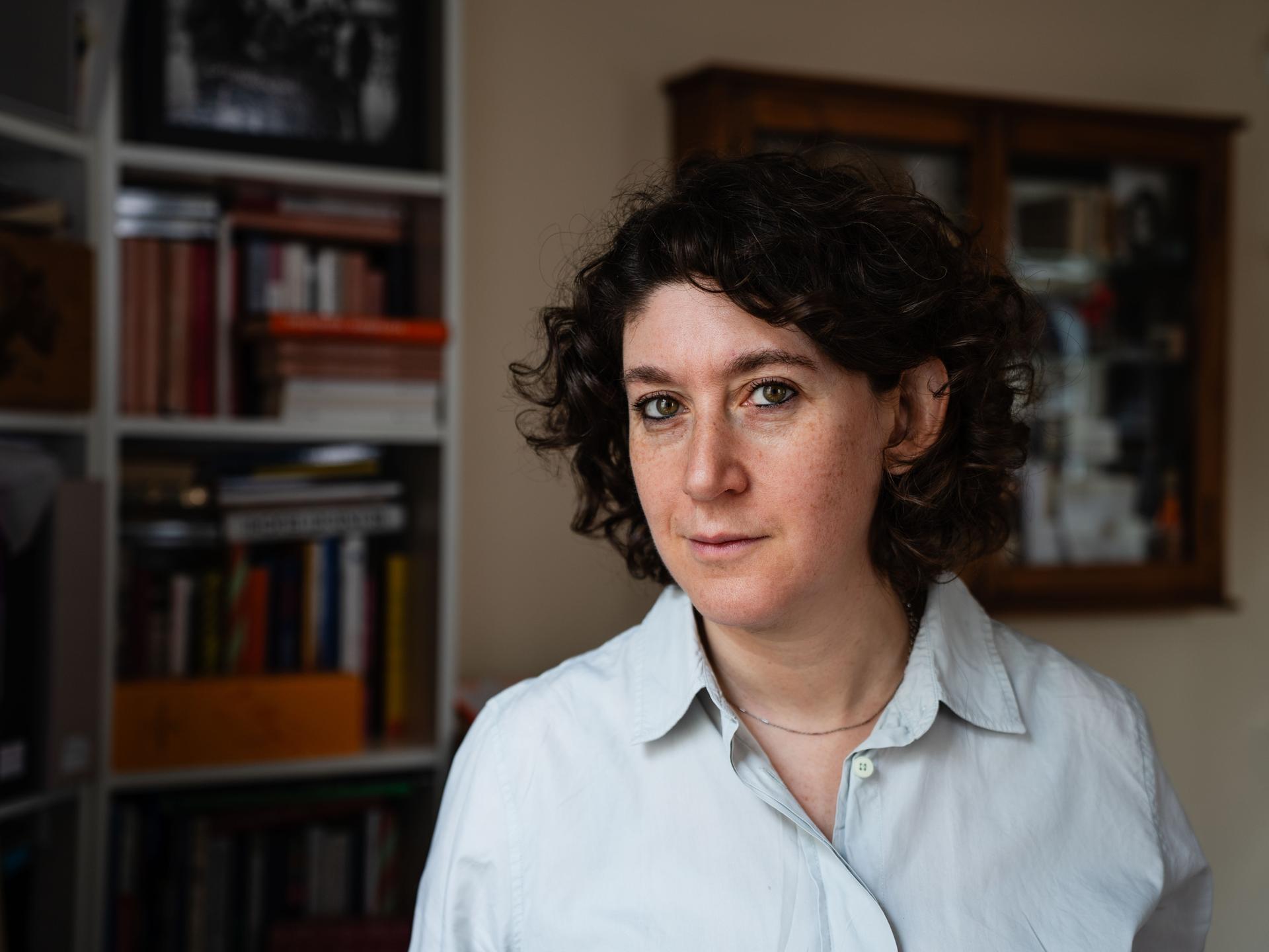 Die Autorin Lena Gorelik blickt in die Kamera, links von ihr ist ein Bücherregal.