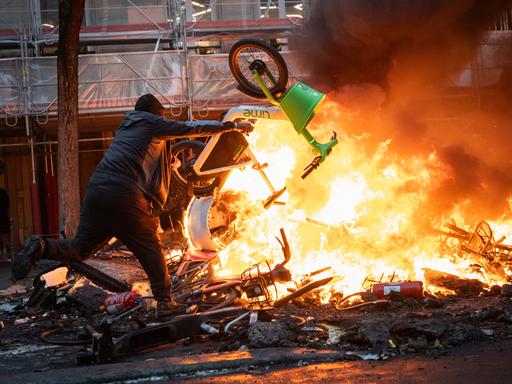 Demonstranten werfen während einer Kundgebung gegen die „hohen Lebenshaltungskosten“ am 17. Oktober 2026 auf der Place de la République in Paris einen Gegenstand in die Flammen. Demonstranten werfen während einer Kundgebung gegen die „hohen Lebenshaltungskosten“ am 17. Oktober 2026 auf der Place de la République in Paris einen Gegenstand in die Flammen.