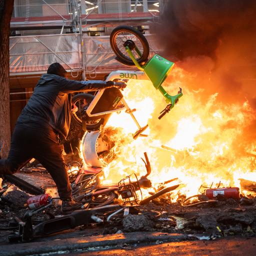 Demonstranten werfen während einer Kundgebung gegen die „hohen Lebenshaltungskosten“ am 17. Oktober 2026 auf der Place de la République in Paris einen Gegenstand in die Flammen. 