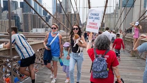 Menschen marschieren über die Brooklyn Bridge, um beim "March for Our Lives" (Marsch für unser Leben) und der Kundgebung am 11. Juni 2022 in New York City gegen Waffengewalt zu protestieren. Auf einem Plakat steht Change Gun Laws or Change Congress.