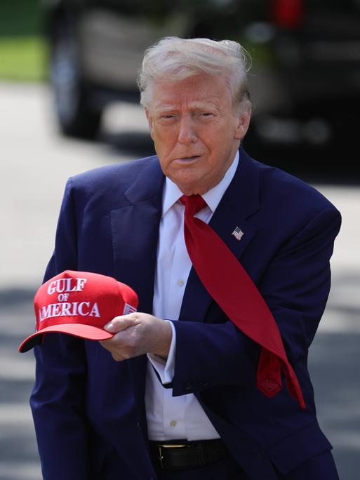 US-Präsident Donald Trump hält eine rote Basecap mit der Aufschrift "Gulf of America" in der Hand