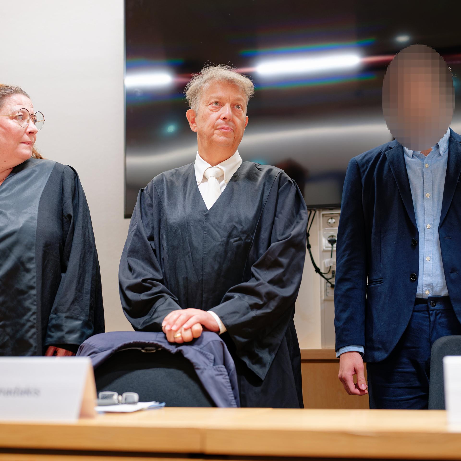 09.07.2026, Rheinland-Pfalz, Zweibrücken: Der Angeklagte (r) steht im Verhandlungssaal des Landgerichts neben seinen Rechtsanwälten Dimitrios Giannadakis (M) und Barbara Schammer. 