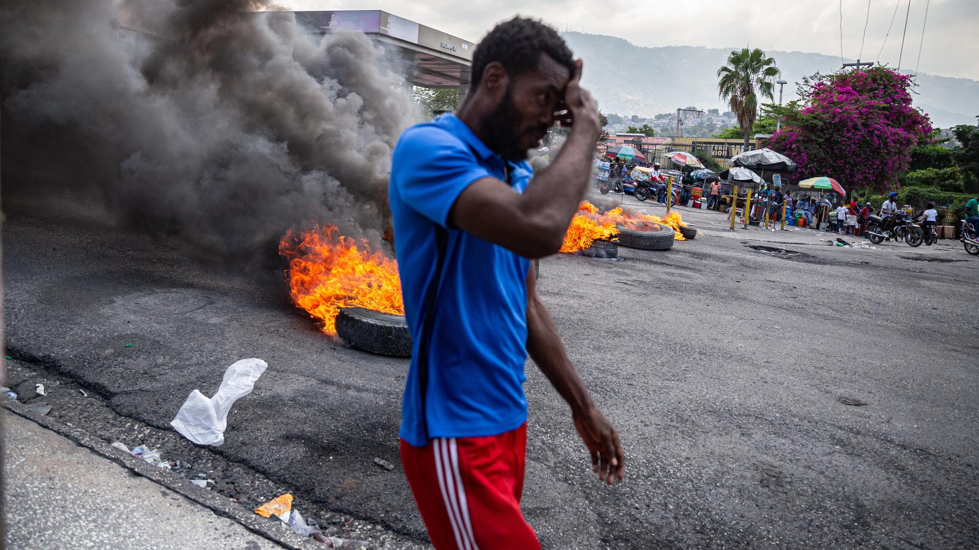 Ein Mann läuft an brennenden Autoreifen in der haitianischen Hauptstadt Port-au-Prince vorbei.
