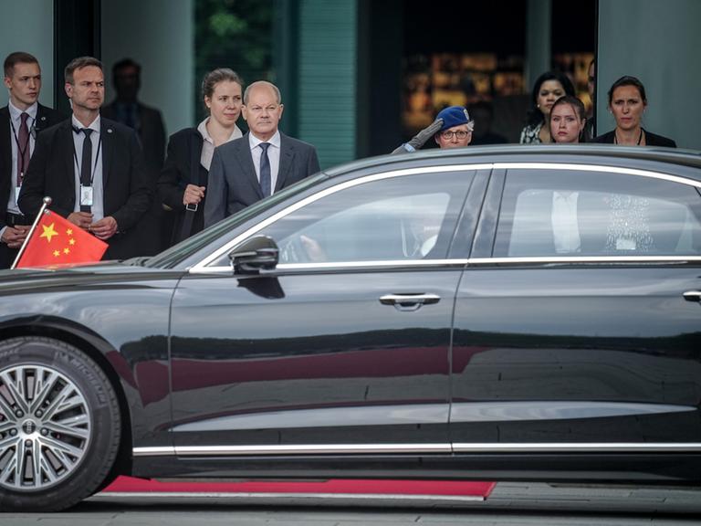 Bundeskanzler Olaf Scholz (SPD, M) wartet auf den chinesischen Ministerpräsidenten Li Qiang, dessen Limousine gerade vorgefahren ist.