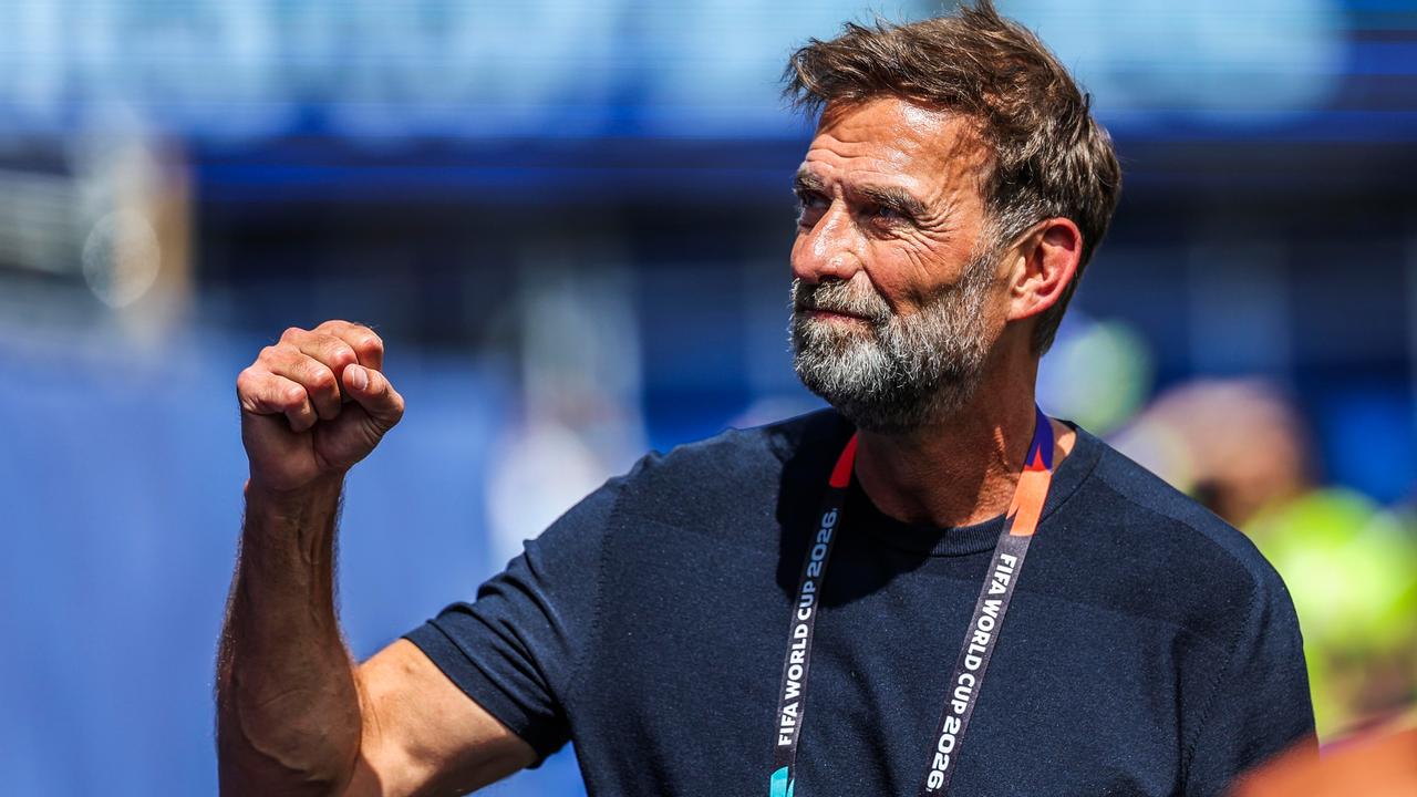 Jürgen Klopp ballt eine Hand zur Faust und schaut zur Seite. Er trägt ein dunkelblaues T-Shirt und ein Band zur Fußball-Weltmeisterschaft um den Hals.