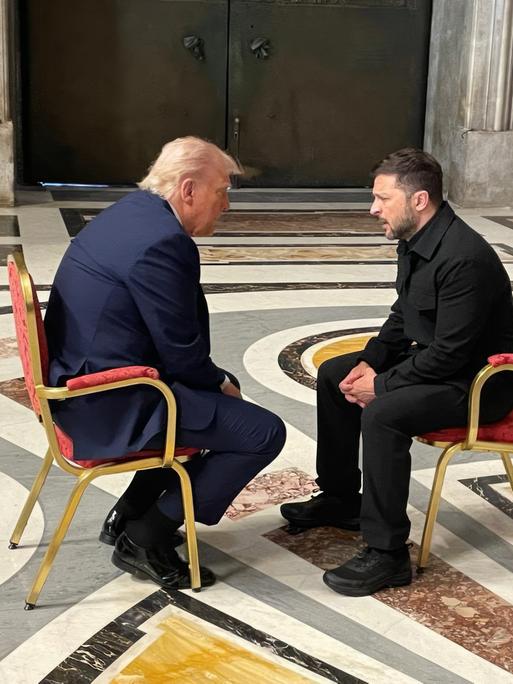 Selenskyj und Trump sitzen sich auf zwei Stühlen während der Beerdigung von Papst Franziskus im Petersdom