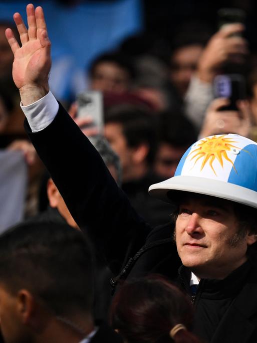 Der argentinische Präsident Javier Milei trägt einen Helm in den Nationalfarben Blau und Weiß.