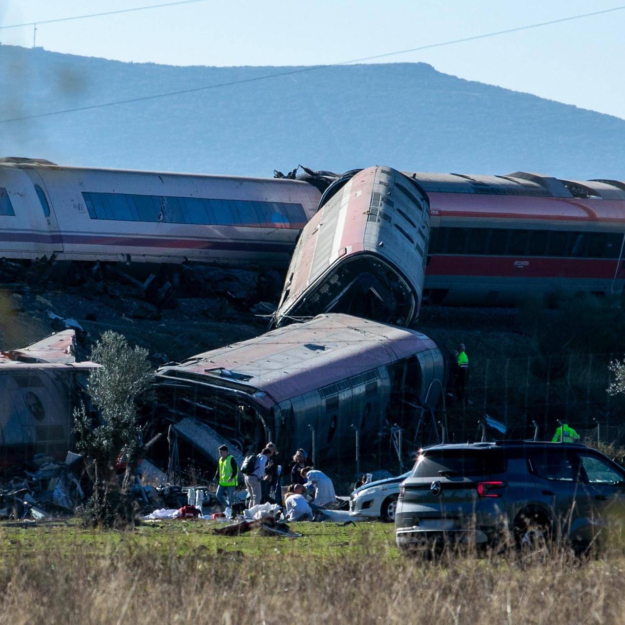 Rettungssanitäter und Helfer bemühen sich um die Menschen in den umgestürzten Waggons.