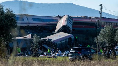 Rettungssanitäter und Helfer bemühen sich um die Menschen in den umgestürzten Waggons.