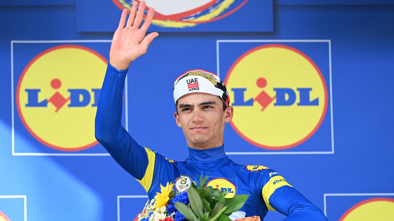 Radsport: Deutschland Tour - Der Mexikaner Isaac del Toro bejubelt seinen Gesamtsieg. Er hält einen Blumenstrauß in der einen Hand und winkt mit der anderen.
