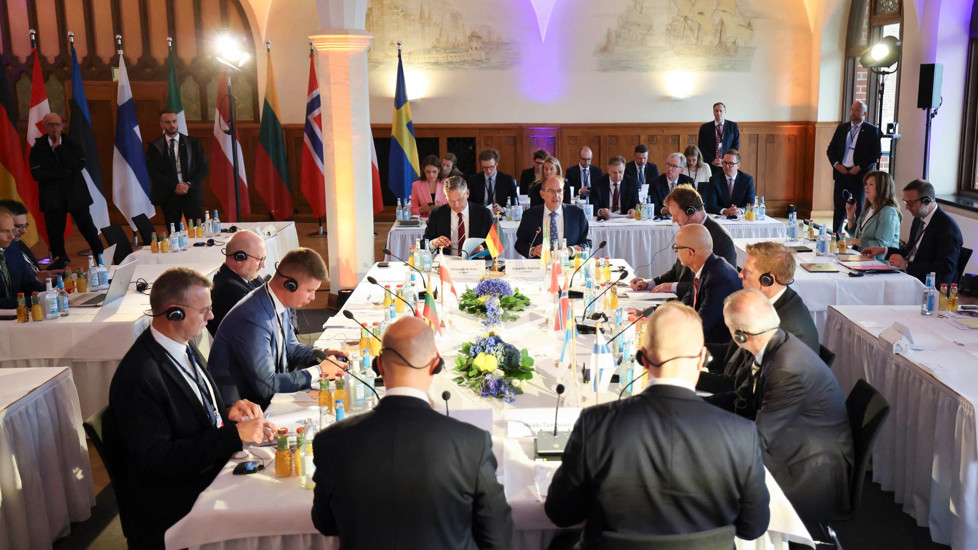 Innenminister Dobrindt, Christoph de Vries, Parlamentarischer Staatssekretär beim Bundesminister des Inneren, und weitere Teilnehmerinnen und Teilnehmer des Baltic Sea Security Summit, zu Beginn der Konferenz im Hauptgebäude der Marineschule Mürwik.