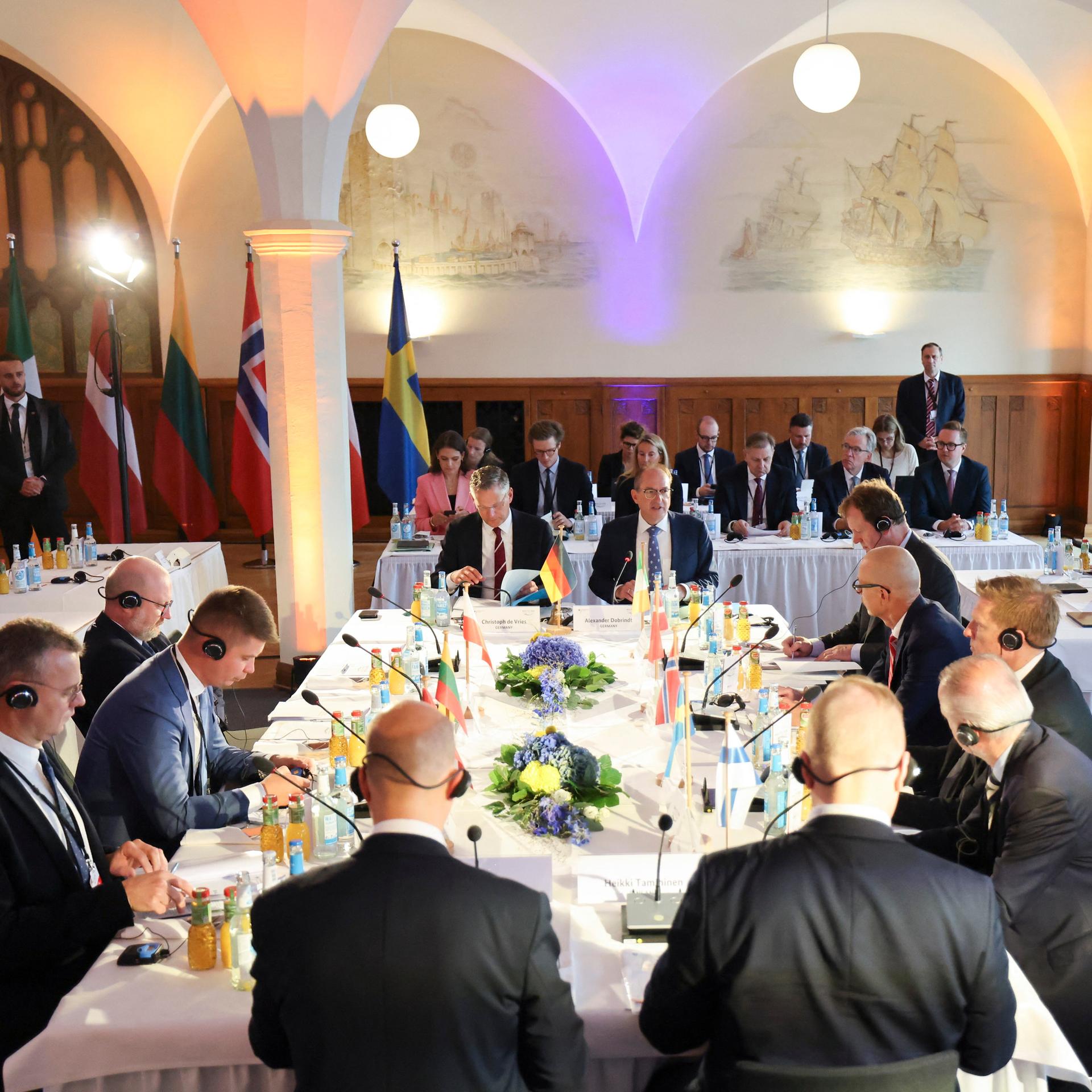 Innenminister Dobrindt, Christoph de Vries, Parlamentarischer Staatssekretär beim Bundesminister des Inneren, und weitere Teilnehmerinnen und Teilnehmer des Baltic Sea Security Summit, zu Beginn der Konferenz im Hauptgebäude der Marineschule Mürwik.