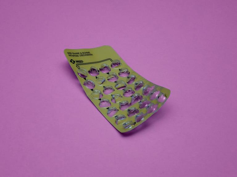 Leerer Blister der Antibabypille liegt auf einem violetten Hintergrund.