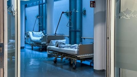 Leere Betten stehen auf einer Krankenhausstation im Gang.
