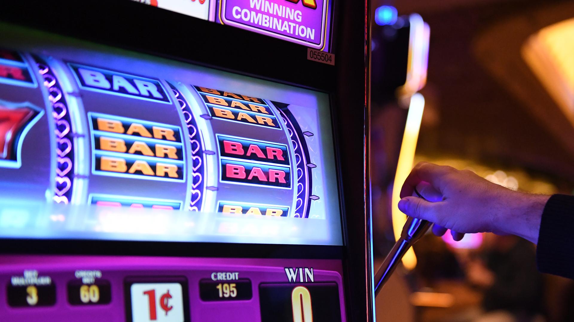 Ein Mann bedient einen Glücks-Spiel-Automaten. Ein Mann bedient einen Glücks-Spiel-Automaten.