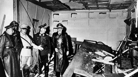 Reichsmarschall Hermann Göring (in heller Uniform) und der Chef der "Kanzlei des Führers", Martin Bormann (links), begutachten die Zerstörung im Raum der Karten-Baracke im Führerhauptquartier Rastenburg, wo Oberst Stauffenberg am 20. Juli 1944 eine Sprengladung zündete, mit der Absicht Hitler, zu töten (Archivfoto vom 20.07.1944).